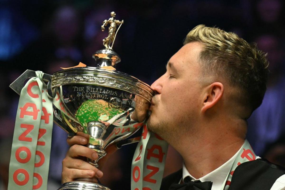 England's Kyren Wilson kisses the trophy after victory over Wales' Jak Jones on day two of their World Championship Snooker final at The Crucible in Sheffield, northern England on May 6, 2024. Wilson won the final 18-14. Oli SCARFF / AFP