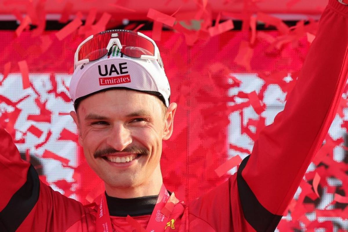 UAE Team Emirates' Australian cyclist Jay Vine celebrates being the leader of the race on the podium following stage 6 of the 6th UAE Cycling Tour from the Louvre Abu Dhabi to Abu Dhabi Breakwater on February 24, 2024. Giuseppe CACACE / AFP