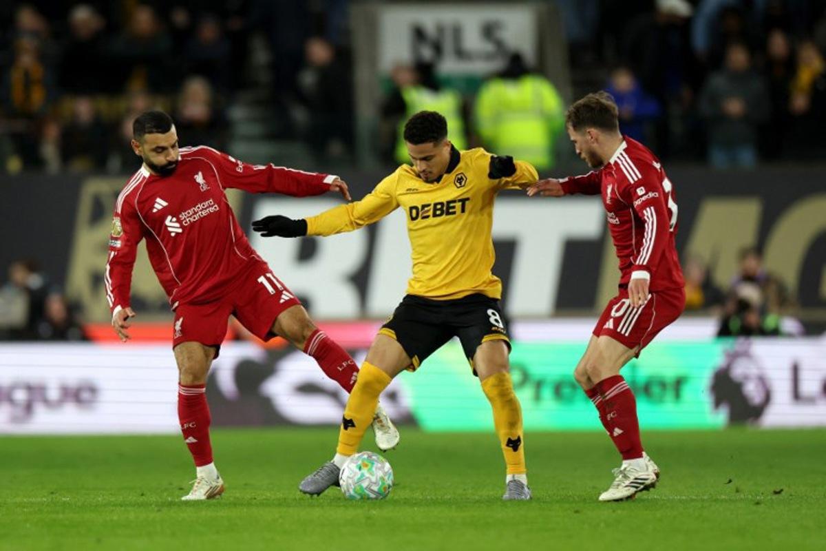 Wolverhampton Wanderers' Brazilian midfielder #08 Joao Gomes is put under pressure by Liverpool's Egyptian striker #11 Mohamed Salah (L) and Liverpool's Argentinian midfielder #10 Alexis Mac Allister during the English Premier League football match between Wolverhampton Wanderers and Liverpool at the Molineux stadium in Wolverhampton, central England on March 3, 2026. Darren Staples / AFP