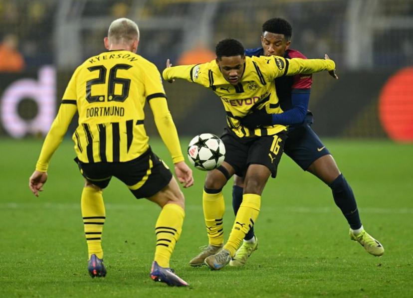 Borussia Dortmund's Belgian forward #16 Julien Duranville (C), Borussia Dortmund's Norwegian defender #26 Julian Ryerson (L) and Barcelona's Spanish defender #03 Alex Balde vie for the ball during the UEFA Champions League football match between Borussia Dortmund and FC Barcelona in Dortmund, western Germany on December 11, 2024. INA FASSBENDER / AFP