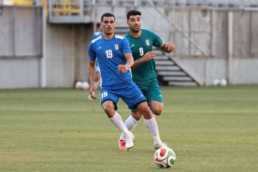 Iran's forward #9 Mehdi Taremi (green) and Iran's defender #19 Milad Mohammadi (blue) practice during a training session as part of the team's preparation for the upcoming football World Cup at the Iranian national team's base camp in Antalya on May 26, 2026. Oner SAN / AFP