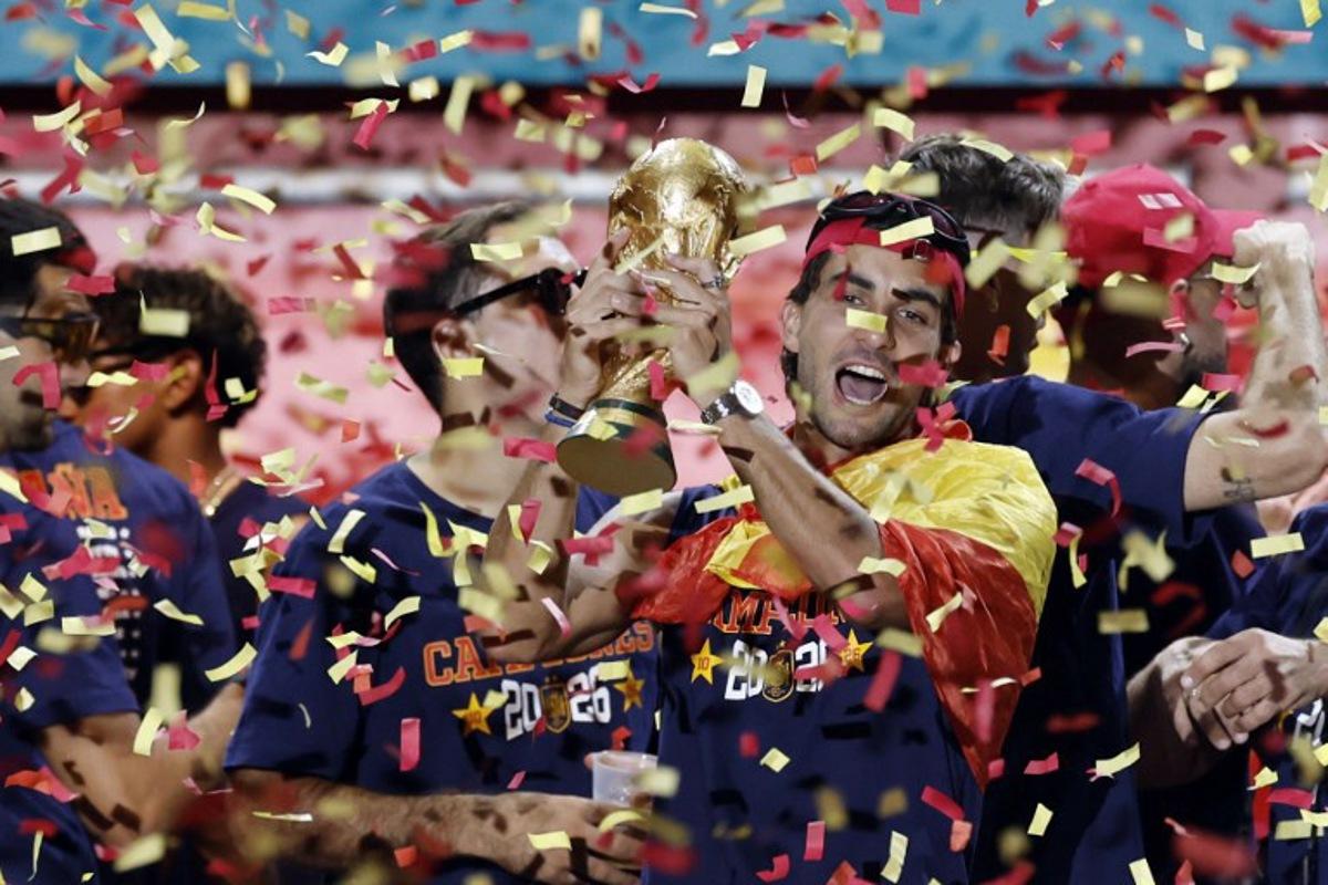Spain's forward Ferran Torres raises the trophy as Spain's players celebrate on a stage at Cibeles Square in Madrid on July 20, 2026, one day after winning their second World Cup title following a 1-0 victory against Argentina. Spain's World Cup winners come back home to a heroes' welcome in Madrid, where a million fans are expected to greet them after a night of raucous celebrations across the country. Oscar DEL POZO / AFP
