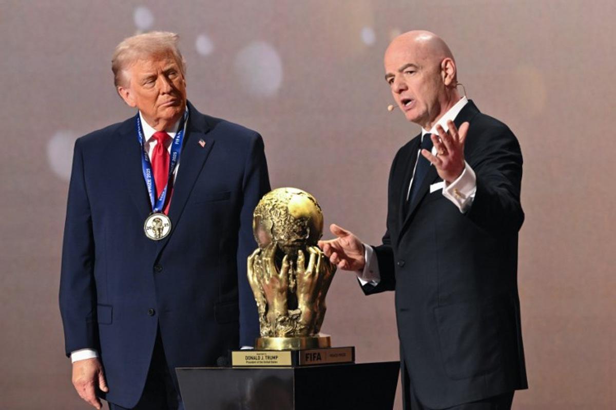 (L/R) US President Donald Trump looks on as he receives the FIFA Peace Prize from FIFA President Gianni Infantino during the draw for the 2026 FIFA Football World Cup taking place in the US, Canada and Mexico, at the Kennedy Center, in Washington, DC, on December 5, 2025. Mandel NGAN / POOL / AFP