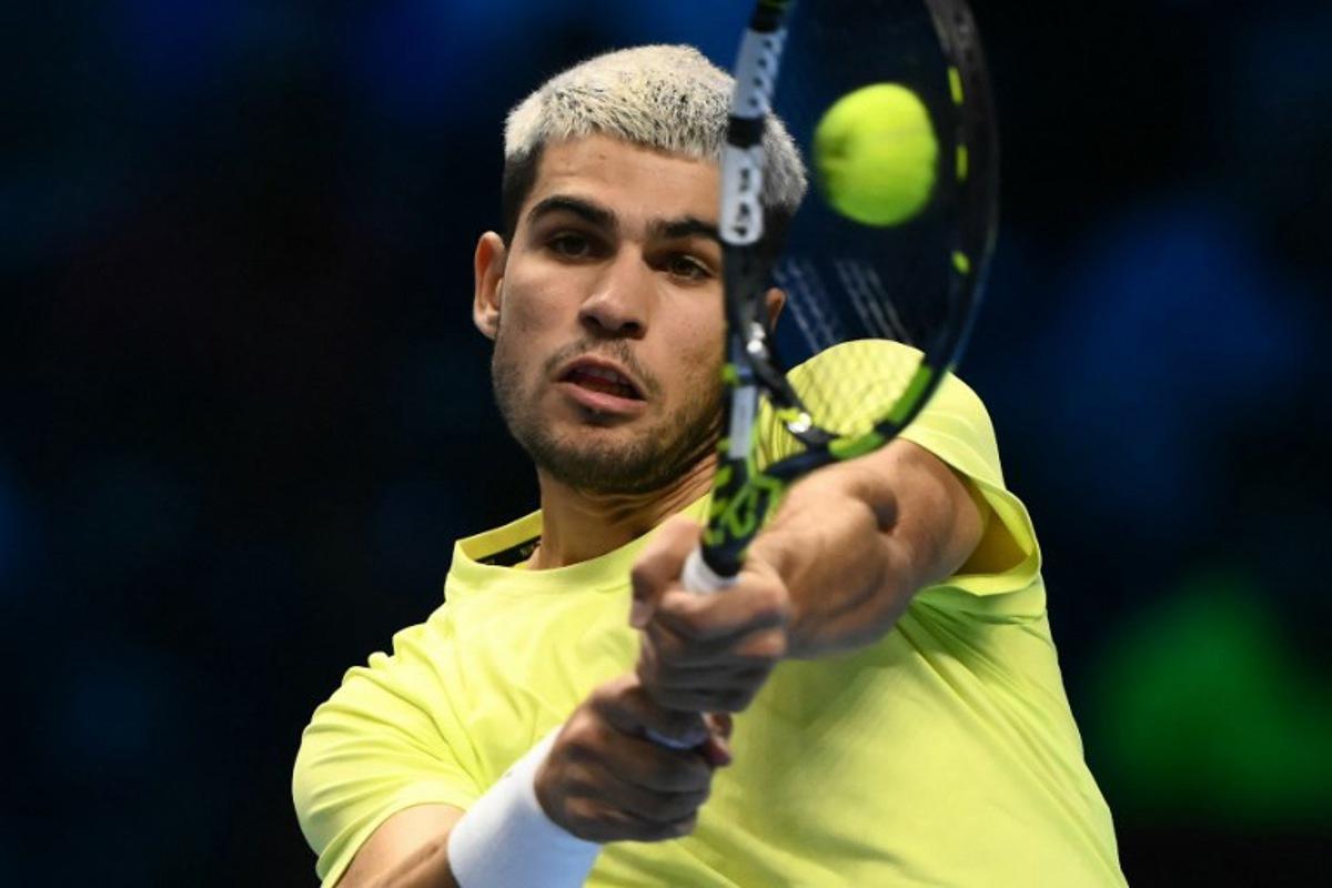 Spain's Carlos Alcaraz hits the ball during his match against Italy's Lorenzo Musetti at the ATP Finals tennis tournament in Turin on November 13, 2025. Marco BERTORELLO / AFP