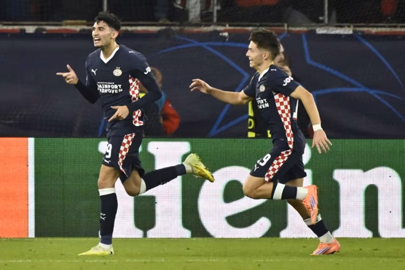 PSV Eindhoven's US forward #09 Ricardo Pepi (L) celebrates after scoring PSV's first goal during the UEFA Champions League first round day 4 football match between Olympiakos (GRE) and PSV Eindhoven (NED) at the Karaiskakis stadium in Piraeus on November 4, 2025. Aris MESSINIS / AFP