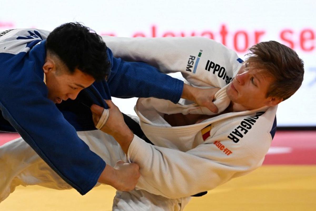 Belgiam's Matthias Casse (white) and Japan's Yuhei Oino (blue) compete in the men's -81kg category quarter-final match at the Tokyo Grand Slam judo competition in Tokyo on December 7, 2025. Toshifumi KITAMURA / AFP