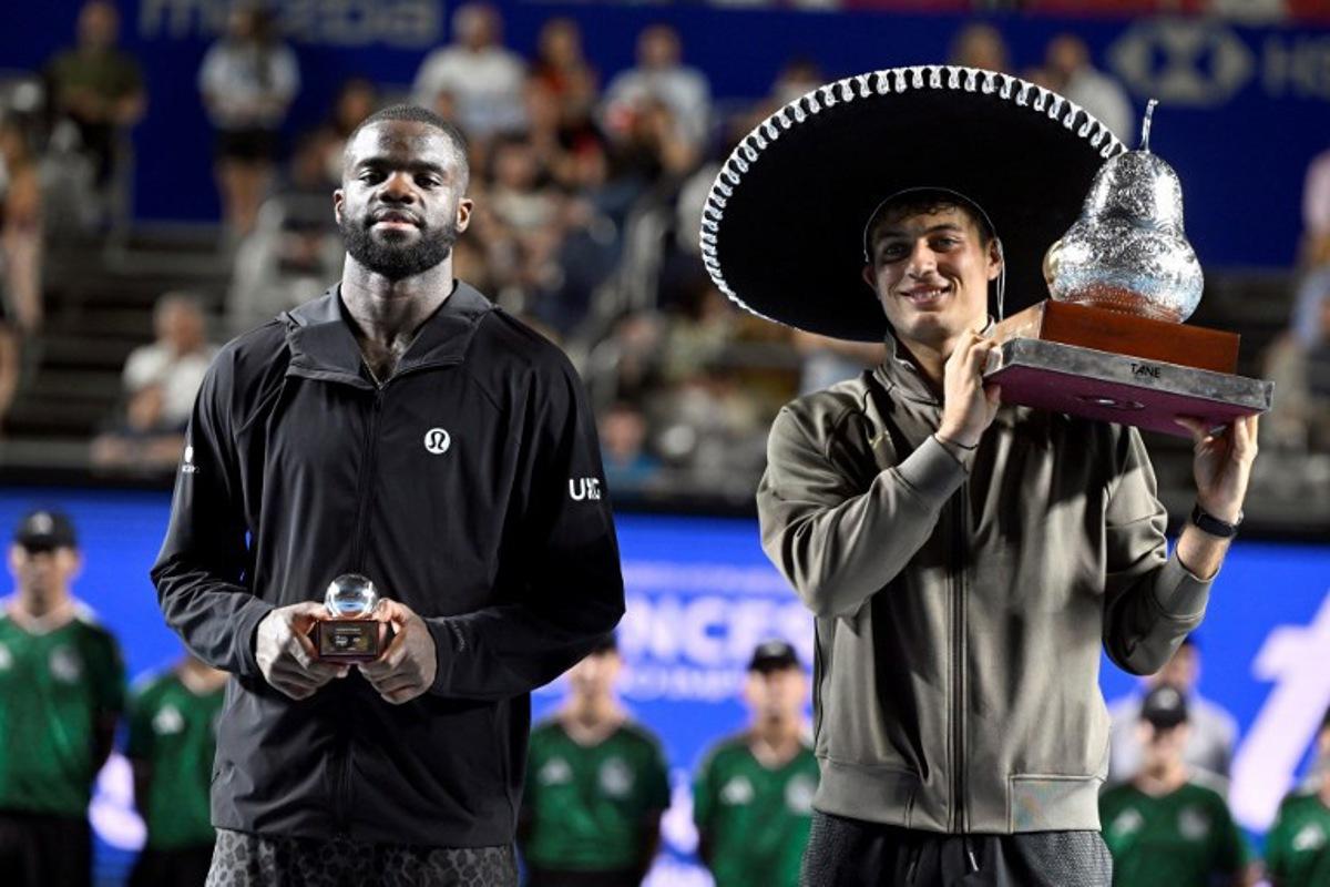 Italy's Flavio Cobolli (R) poses with his trophy after defeating US' Frances Tiafoe (L) during the 2026 Mexico ATP 500 Tennis Open men's singles tennis final match at the Arena GNP Seguros in Acapulco, Guerrero State, Mexico on February 28, 2026. Alfredo ESTRELLA / AFP
