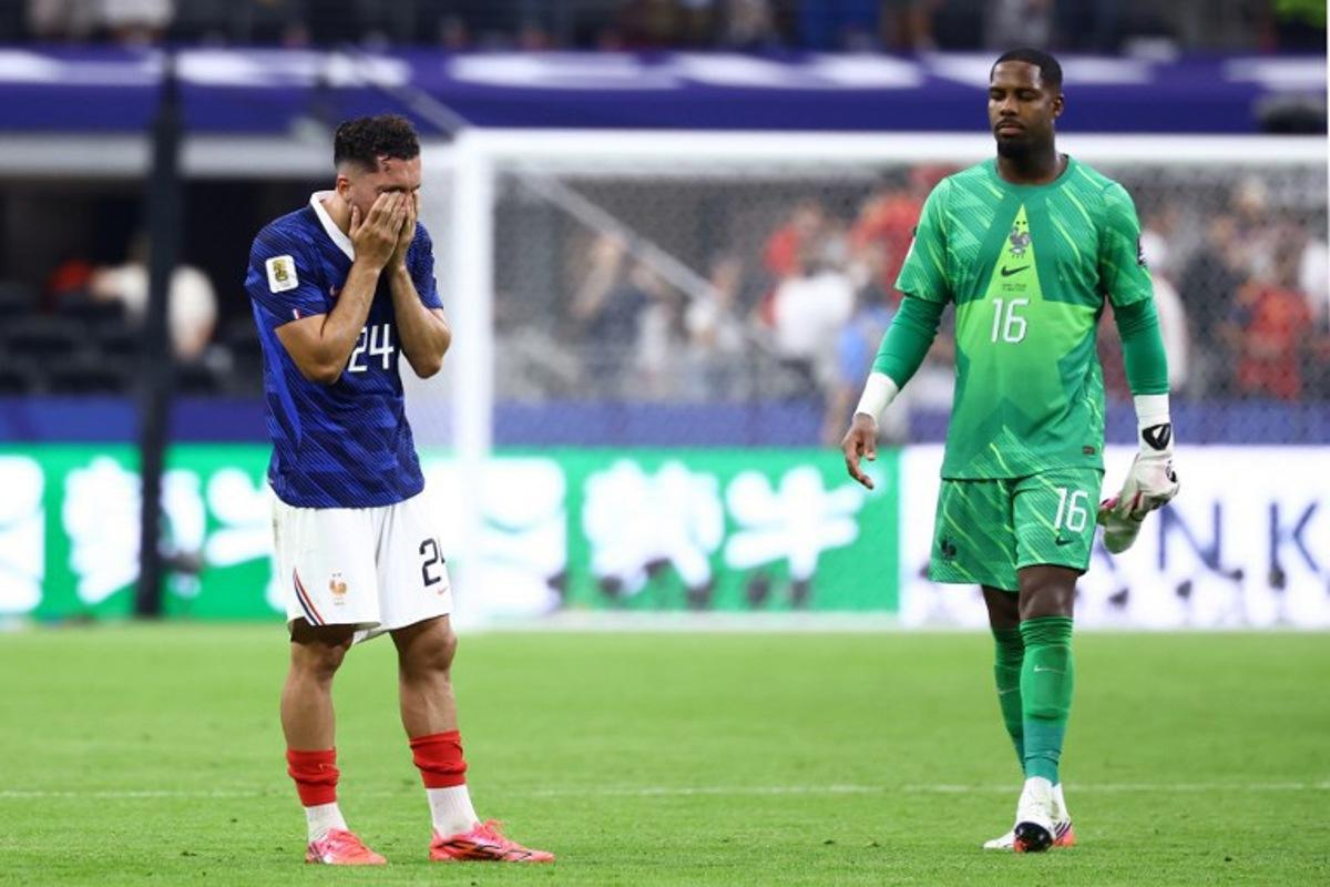 France's forward #24 Rayan Cherki and goalkeeper #16 Mike Maignan react after losing the 2026 World Cup football tournament semi-final match between France and Spain at the Dallas Stadium in Arlington on July 14, 2026. CHARLY TRIBALLEAU / AFP