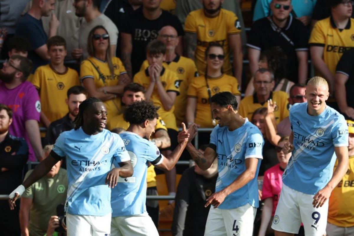 Manchester City's Dutch midfielder #04 Tijjani Reijnders (2R) celebrates scoring their second goal with Manchester City's Belgian midfielder #11 Jeremy Doku (L), Manchester City's Norwegian midfielder #52 Oscar Bobb (2L) and Manchester City's Norwegian striker #09 Erling Haaland (R) during the English Premier League football match between Wolverhampton Wanderers and Manchester City at the Molineux stadium in Wolverhampton, central England on August 16, 2025. Darren Staples / AFP