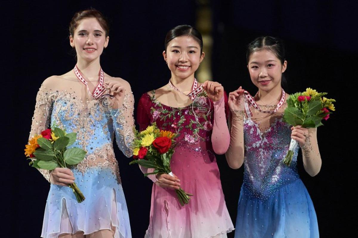 Gold medalist Mone Chiba of Japan (C) poses with silver medalist Isabeau Levito of the United States (L) and Ami Nakai of Japan during the victory ceremony for the women's competition during the ISU Grand Prix of Figure Skating 2025 Skate Canada International at the SaskTel Centre in Saskatoon, Saskatchewan, Canada on November 1, 2025. Geoff Robins / AFP