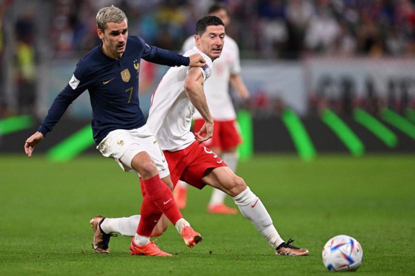 France's forward #07 Antoine Griezmann (L) fights for the ball with Poland's forward #09 Robert Lewandowski during the Qatar 2022 World Cup round of 16 football match between France and Poland at the Al-Thumama Stadium in Doha on December 4, 2022. Kirill KUDRYAVTSEV / AFP
