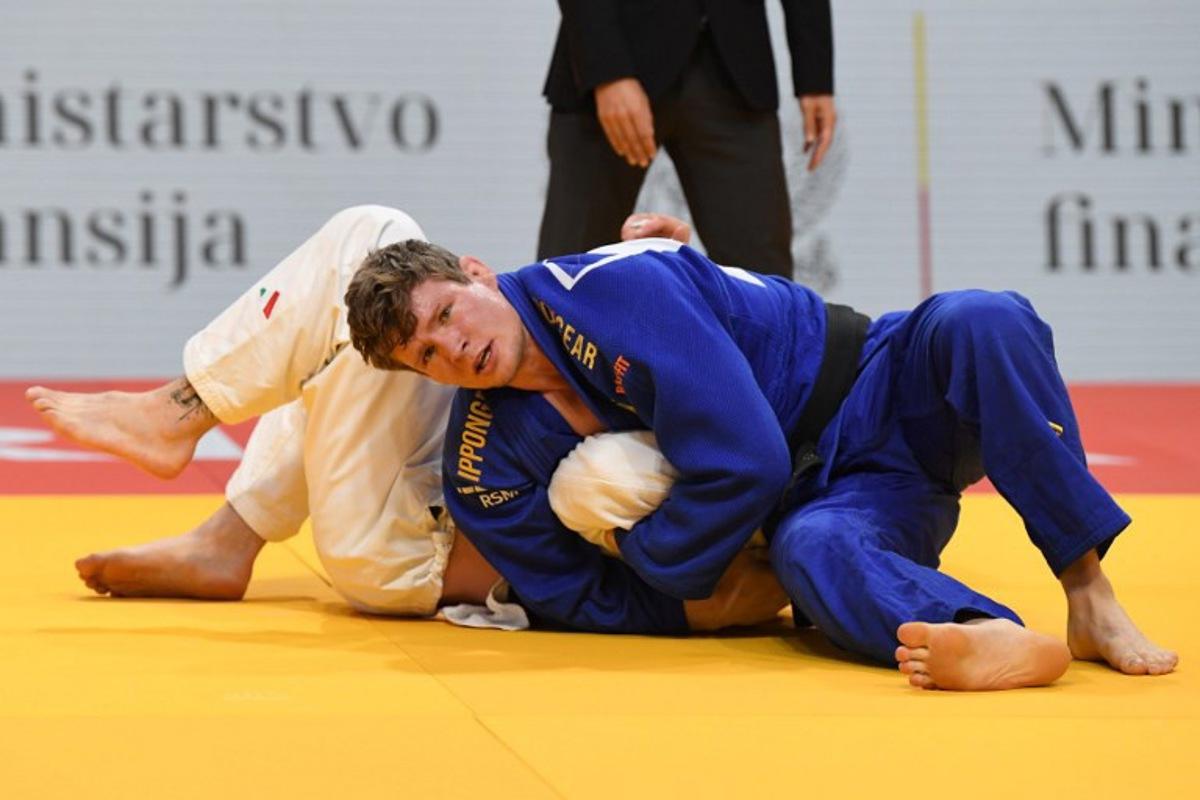 Belgium's Matthias Casse (blue) and Italy's Antonio Esposito (white) compete in the men's -81kg category during the European Championships judo in Podgorica, Montenegro, on April 25, 2025. The tournament is taking place from April 23 to 27, 2025. SAVO PRELEVIC / AFP